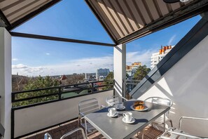 A beautiful balcony with a table and chairs, perfect for enjoying fresh air and scenic views.
