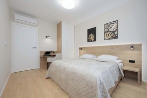 Air conditioned bedroom with desk for comfortable remote work during business trips.