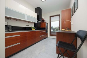 Functional separate kitchen with a coffee maker, a fridge, a kettle, an oven, and a microwave.