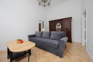 Living room with two sofas, TV, coffee table and closet with mirror.