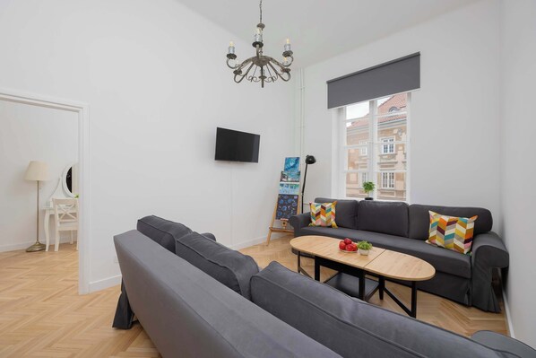 Cozy and bright living room with two sofas, TV, coffee table and other decorative elements.