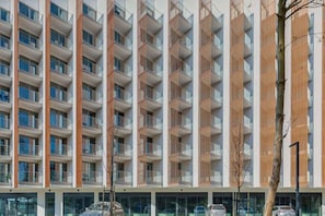 The exterior of a tall, modern apartment building with a unique grid-like design.