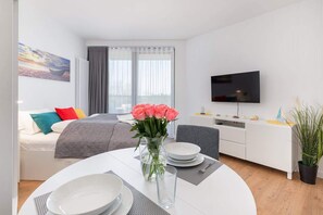A spacious bedroom with a large bed, decorative pillows, and a window letting in plenty of natural light.