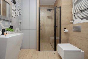 The modern bathroom with a walk-in shower offers comfort and a stylish setting for daily routines.