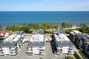 Aerial view of modern seaside buildings just steps away from the sandy beach.