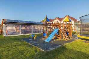 A communal garden with a playground and barbecue area.