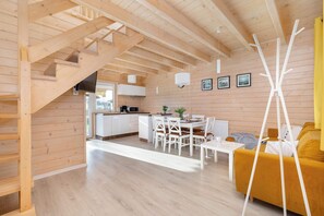 The dining table harmoniously links the living area with the kitchenette.