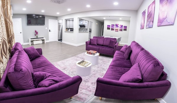 Space equipped with velvet couches, board games, Smart TV and beautiful wall art