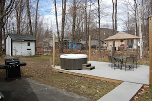 back yard deck with grills and overhead lights with seating for 6 