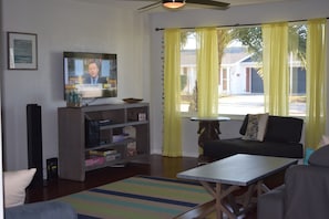 View into living room and outdoors. Great beach hues, seating and entertainment.