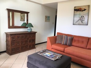 partial living room photo taken from indoor dining area; see hallway to kitchen