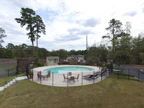 The beautiful swimming pool is located right next to the tennis courts. 