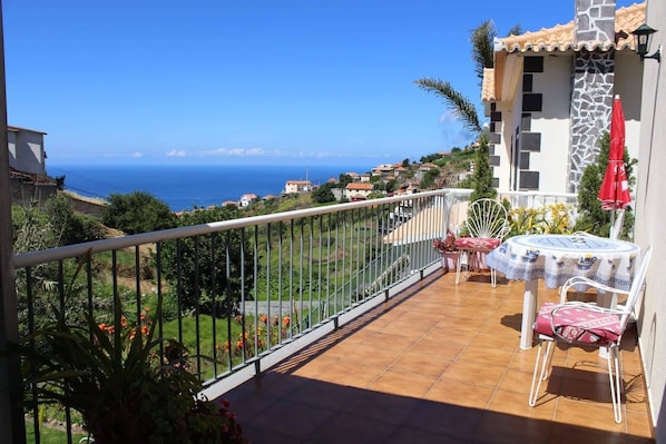 View from the balcony overlooking the valley and the ocean in the distance
