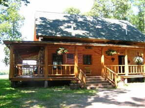 Front view in summer: wrap around porch & hammock
