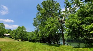 The cabin sits on a small hill above the river bank