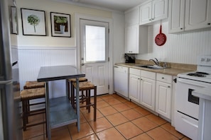 Kitchen with dining area and second entrance leading to fenced yard