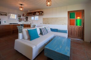 Comfortable sofa bed in studio, kitchen in background