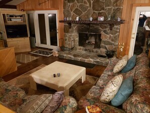 Spacious living room, grand fireplace piano and day bed at Mount Snow Ski Rental