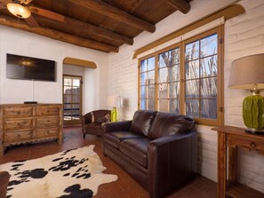 The bright living room features a cowskin rug and natural light