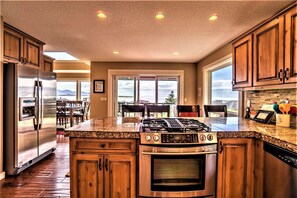 Chef's kitchen w/ stainless steel appliances, granite counters & large pantry