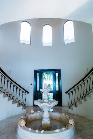 Beautiful grand entry with split spiral staircase and fountain.