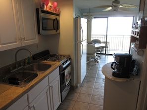 Kitchen with12 cup coffee maker. Full size fridge, microwave 4 burner stovetop.