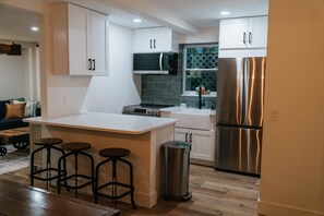 Full kitchen; fridge, induction cook top, dishwasher, farmhouse sink, bar.