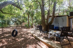 Tire swing in large fenced in backyard shown. 