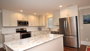 Open kitchen laid out perfect with a food prep and service bar. 