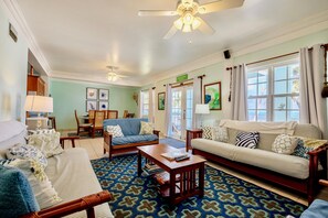 Living room with view to dining area; double doors to porch on right