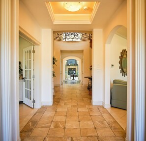 Entry view from the front door into the central hall.  Media room to left.  