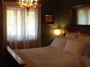 Comfortable queen size bed with rare antique vevenetian chandelier above the bed