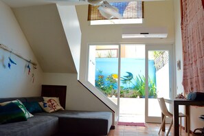 The living with a sofa that makes 2 twin beds. The patio with the pool.