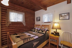 Downstairs bedroom with original log walls.