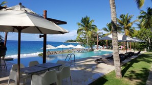 Crystal clear Infinity pool with bar and sunbeds overlooking our private beach.