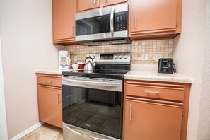 Kitchen w/ microwave, stove, fridge with ice maker, & dishwasher with detergen