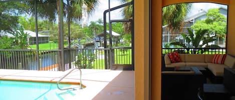 View of canal, pool and lanai with comfortable seating