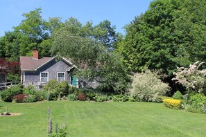 The cottage enclave with spacious lawn is enclosed by gardens & woods.