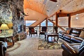 Upstairs sitting area with gas fireplace, massage chair and lake view.