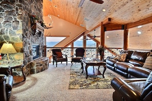 Upstairs sitting area with gas fireplace, massage chair and lake view.