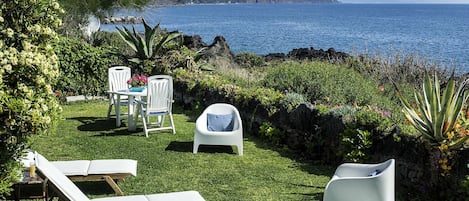 Jardin privé bordant les roches de lave et la mer