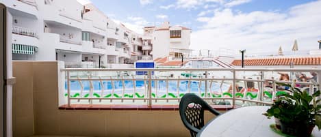 balcony with table chairs overlooking pool