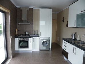 Modern kitchen with oven, hob, washing machine, dishwasher and fridge/freezer