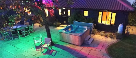 Outdoor area, including hot tub, in the evening