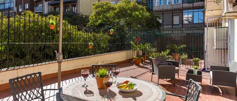 The spacious and sunny terrace looks out onto an interior urban garden