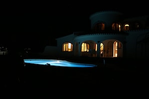 Night time view of pool and house