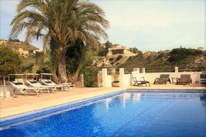 Swimming pool with massive sundeck complete with sun loungers and sunbrellas