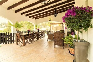 The large wooden beamed porch with large table and chairs for open air dining