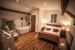 Luxurious bedroom with free standing bath and en-suite toilet and sink