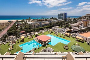 Vistas a las piscinas y a la playa, desde la terraza.